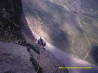 Escalando en la Cara Este, al fondo el camino que sube hacia el collado Suzon desde el refugio de Pombi